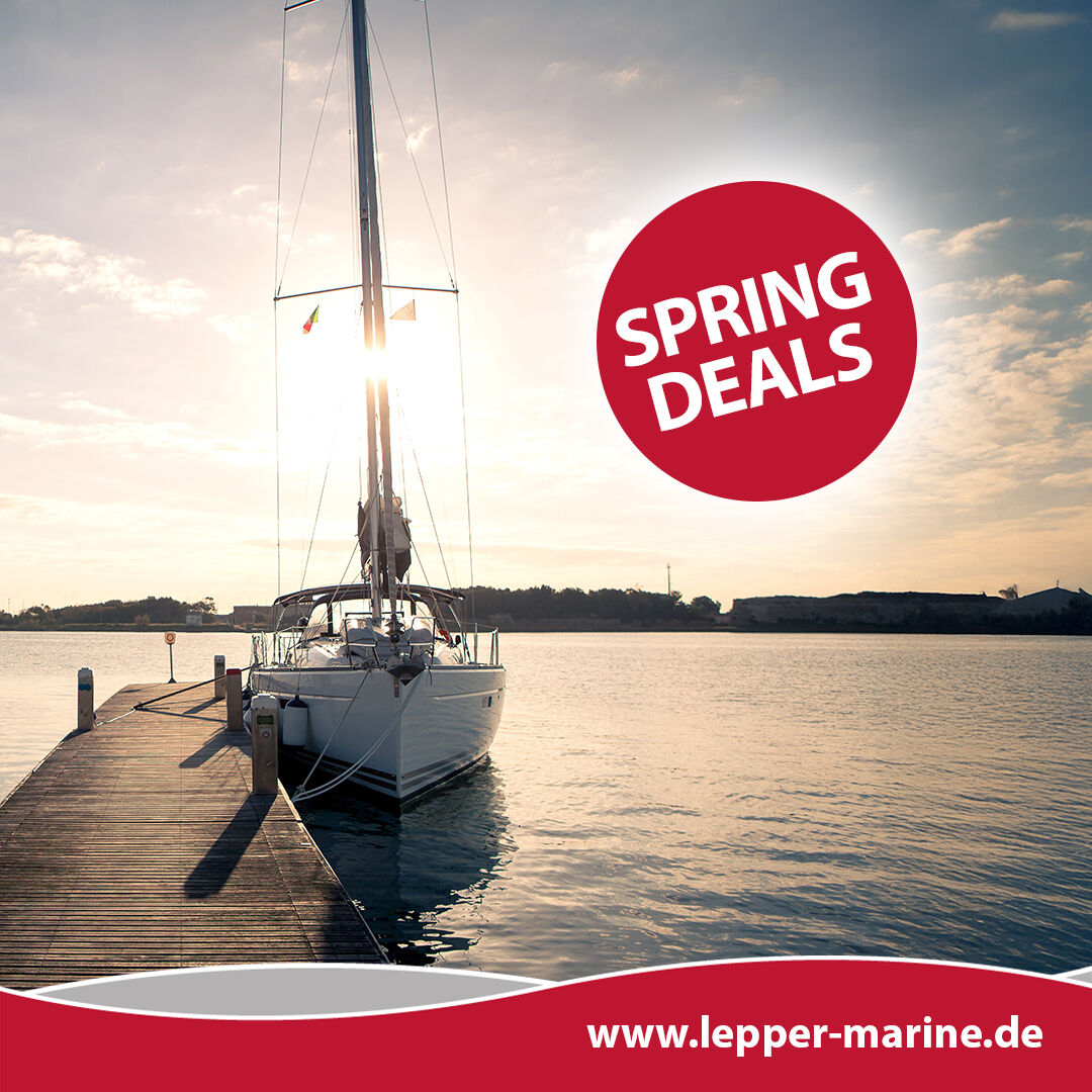 Ein Segelboot liegt im Abendlicht an einem Holzsteg, begleitet von einem roten Spring Deals Aktionslogo.