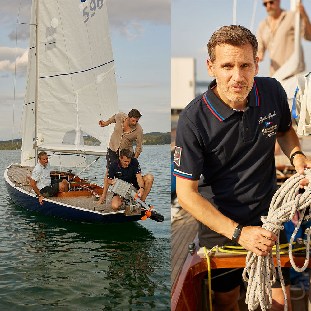 Drei Männer bereiten ein Segelboot vor und montieren einen Torqeedo Außenbordmotor am Heck.