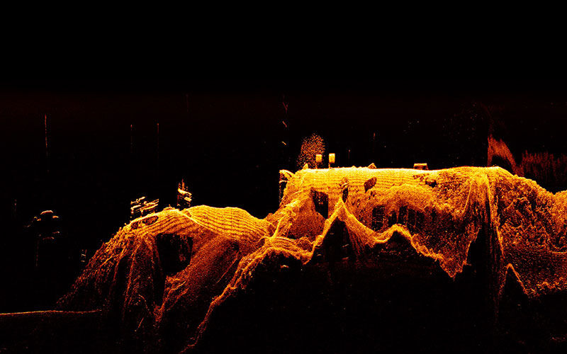 Detailreiches Sonarbild von Unterwasserstrukturen in orange und schwarz.