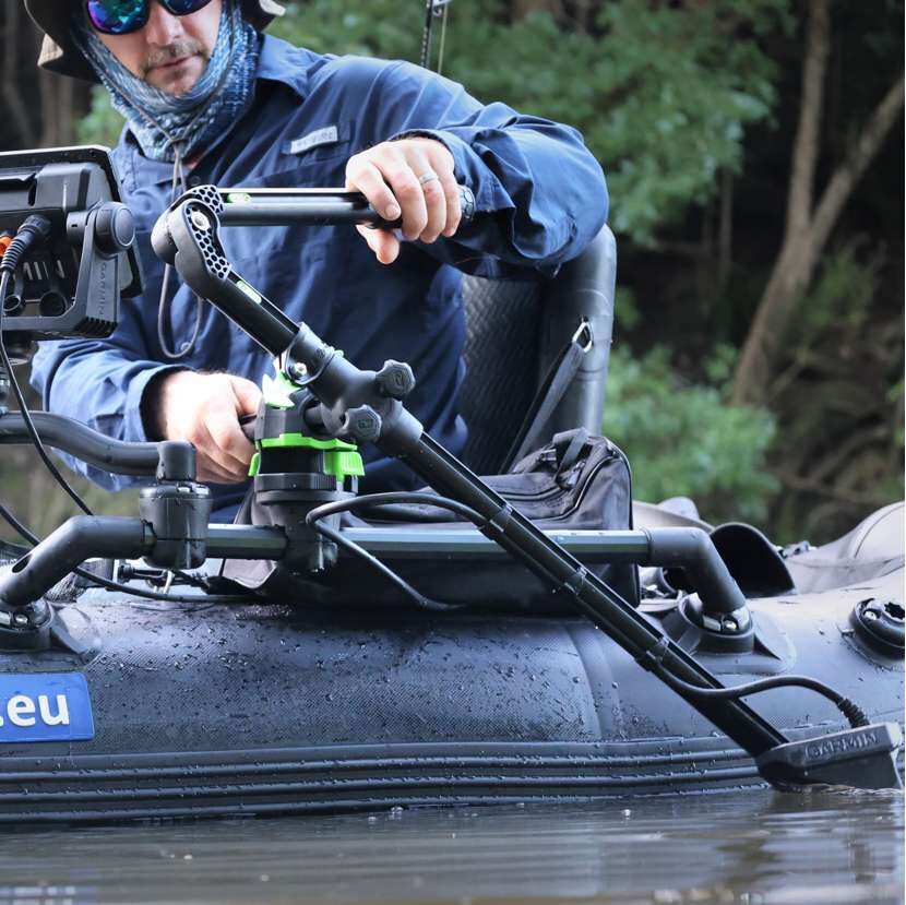 Angler beim Ausrichten der verstellbaren Geberstange an einem schwarzen Bellyboat auf dem Wasser.