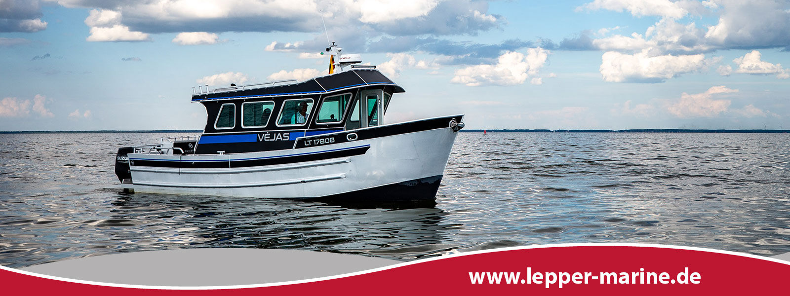 Das Motorboot Lepper Marine Gliseris G99 fährt auf einem ruhigen Gewässer unter bewölktem Himmel.